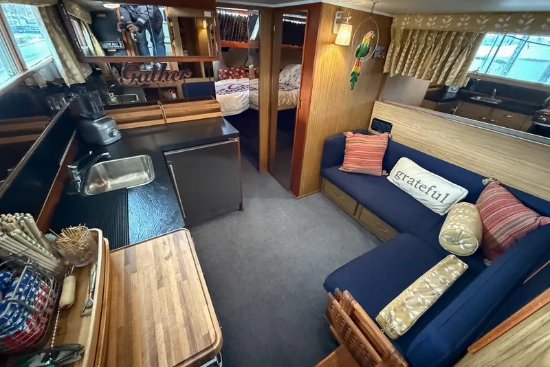 Slide: The Image of 1969 Chris-Craft 338 Commander interior with cozy seating, kitchen, and decorative pillows. - 20