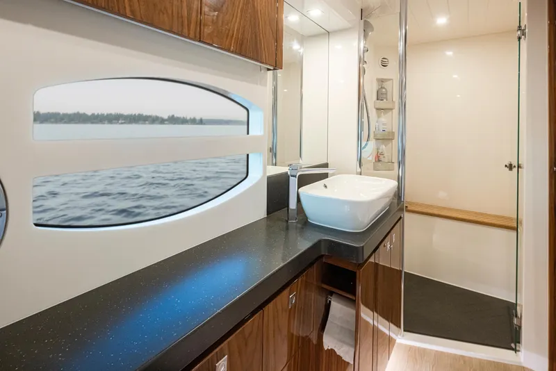 Slide: The Image of Luxurious bathroom interior of 2017 Riviera Sport Cruiser with modern fixtures and scenic window view. - 25