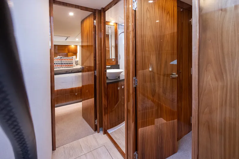 Slide: The Image of 2017 Riviera Sport Cruiser interior with wood finish, showing bedroom and bathroom areas. - 32