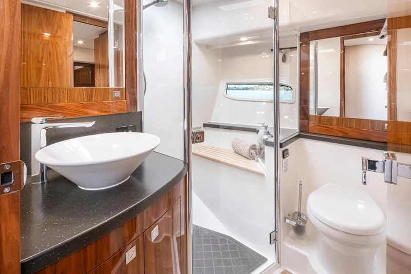 Slide: The Image of Luxurious bathroom in 2017 Riviera Sport Cruiser yacht with modern fixtures and wood accents. - 41