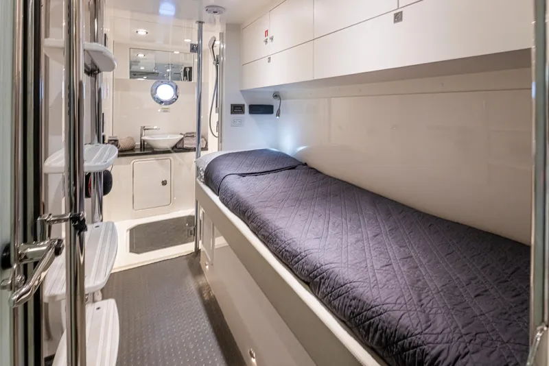 Slide: The Image of 2017 Riviera Sport Cruiser cabin interior with bed, storage, and porthole window. - 48