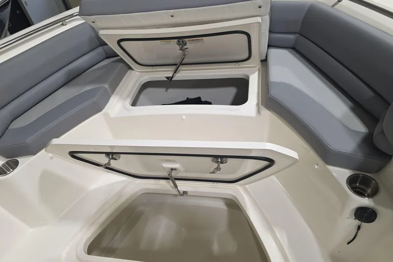Slide: The Image of 2026 Boston Whaler 330 Outrage boat interior with open storage compartments and cushioned seating. - 15