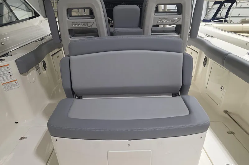 Slide: The Image of 2026 Boston Whaler 330 Outrage interior seating with gray upholstery. - 24