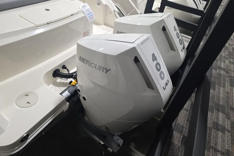 Slide: The Image of 2026 Boston Whaler 330 Outrage with dual Mercury 400 V10 engines, showcased indoors. - 26