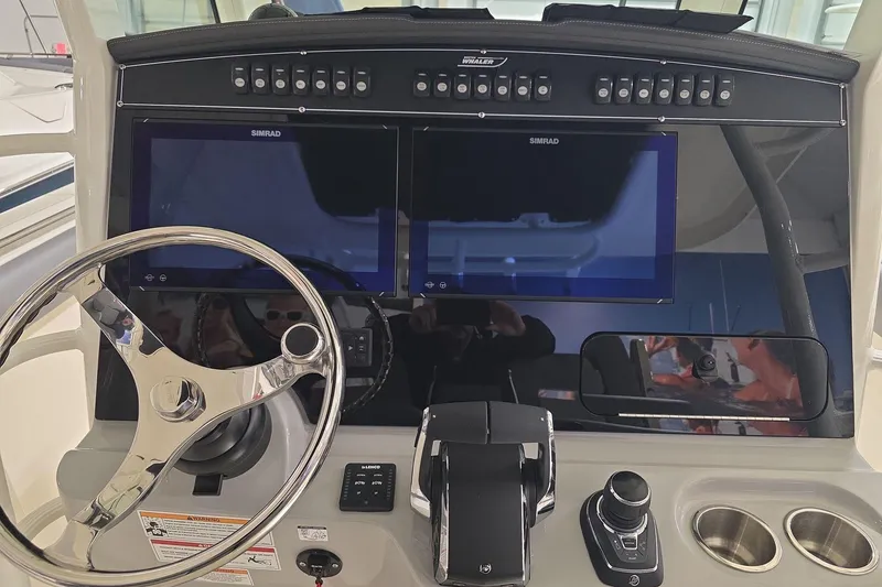 Slide: The Image of 2026 Boston Whaler 330 Outrage helm with dual Simrad displays and modern controls. - 27