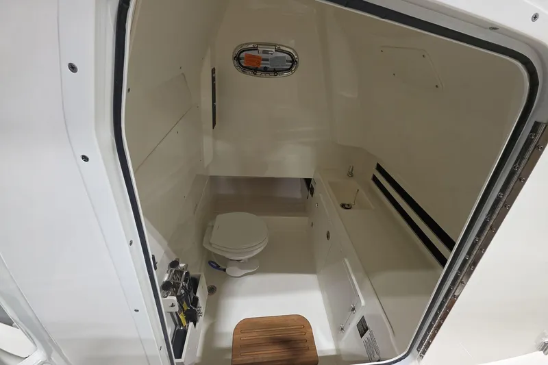Slide: The Image of 2026 Boston Whaler 330 Outrage cabin interior with toilet and sink. - 30