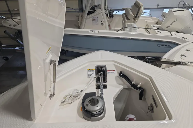 Slide: The Image of 2026 Boston Whaler 330 Outrage boat interior with anchor storage and Mercury engine. - 32