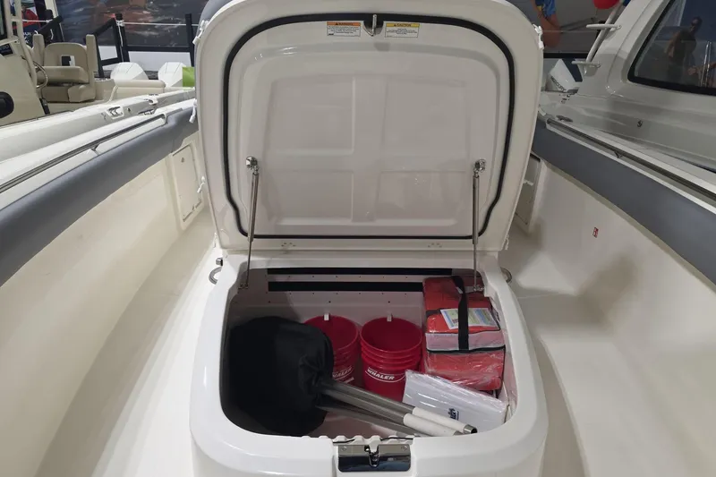 Slide: The Image of 2026 Boston Whaler 330 Outrage storage compartment with safety gear and equipment. - 34