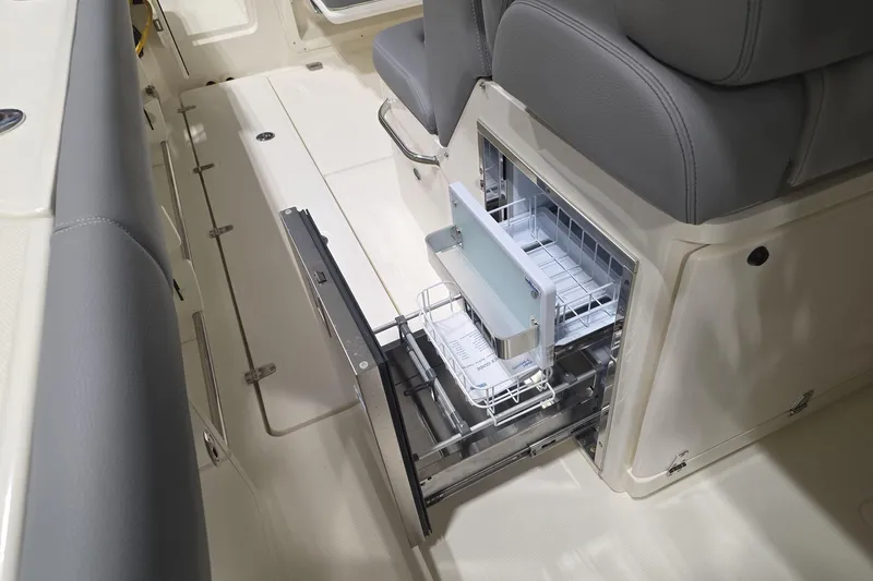 Slide: The Image of 2026 Boston Whaler 330 Outrage interior with open storage compartment and seating. - 38