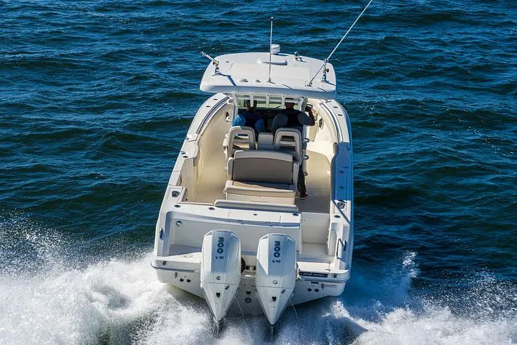 Slide: The Image of Manufacturer Provided Image: 2025 Boston Whaler 330 Outrage cruising on open water, rear view. - 4