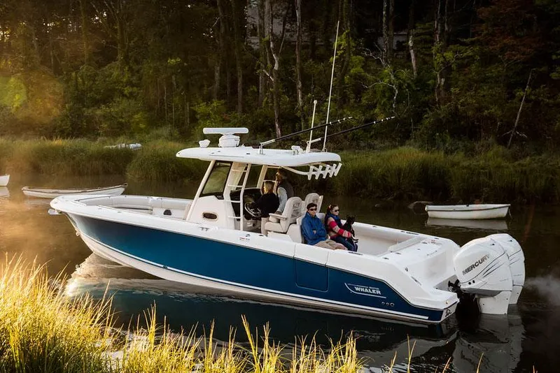 Slide: The Image of Manufacturer Provided Image: 2025 Boston Whaler 330 Outrage boat cruising in a serene, wooded waterway. - 6
