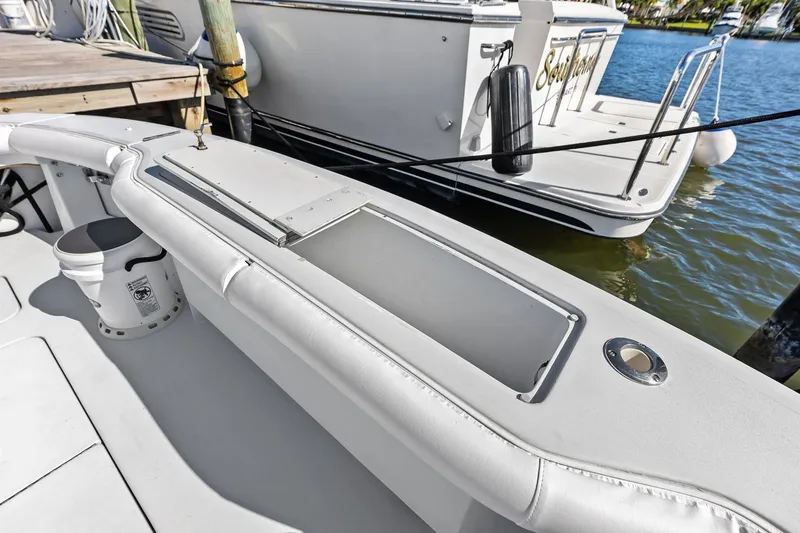 Slide: The Image of 2003 Hatteras 65 Convertible yacht deck with storage compartment and docked boat. - 15