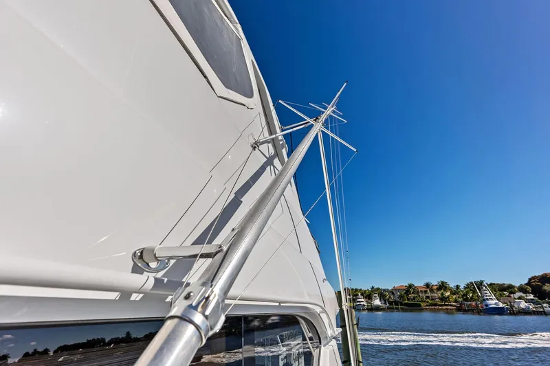 Slide: The Image of 2003 Hatteras 65 Convertible yacht with clear blue sky and waterfront view. - 27