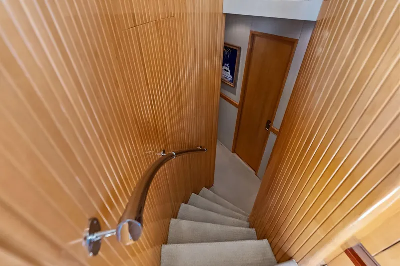 Slide: The Image of Staircase inside 2003 Hatteras 65 Convertible yacht with wooden paneling and handrail. - 41