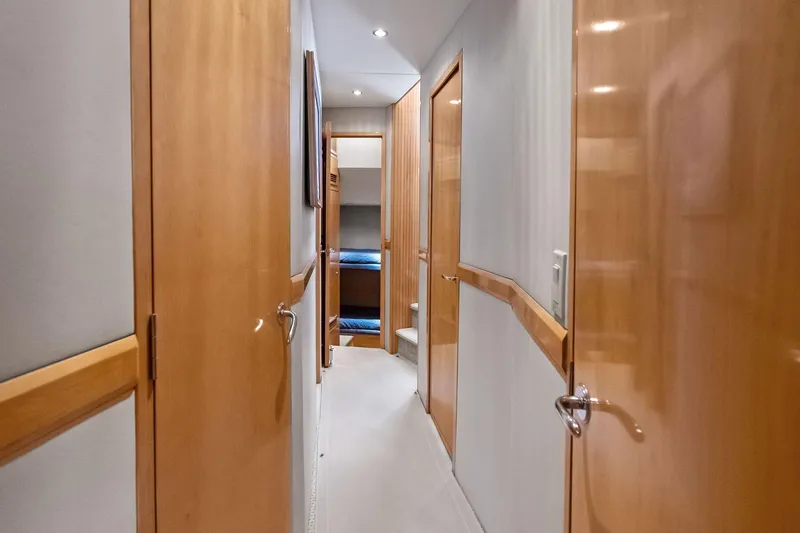 Slide: The Image of Hallway inside 2003 Hatteras 65 Convertible yacht with wooden doors and cozy lighting. - 43