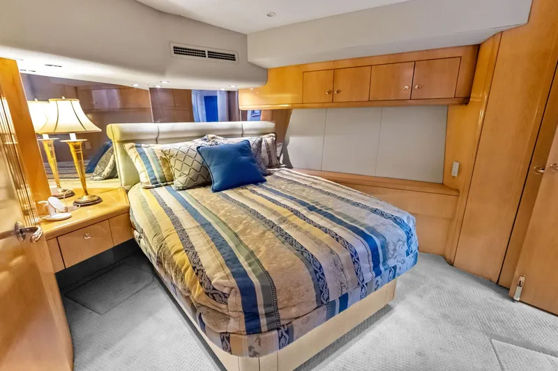 Slide: The Image of Luxurious bedroom interior of 2003 Hatteras 65 Convertible yacht with elegant bedding and wood cabinetry. - 45