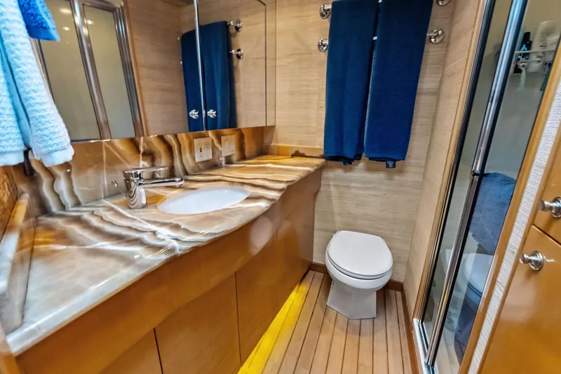 Slide: The Image of Luxurious bathroom in 2003 Hatteras 65 Convertible yacht with marble countertop and wooden flooring. - 48