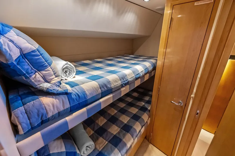 Slide: The Image of Bunk beds with blue checkered bedding in 2003 Hatteras 65 Convertible yacht cabin. - 52