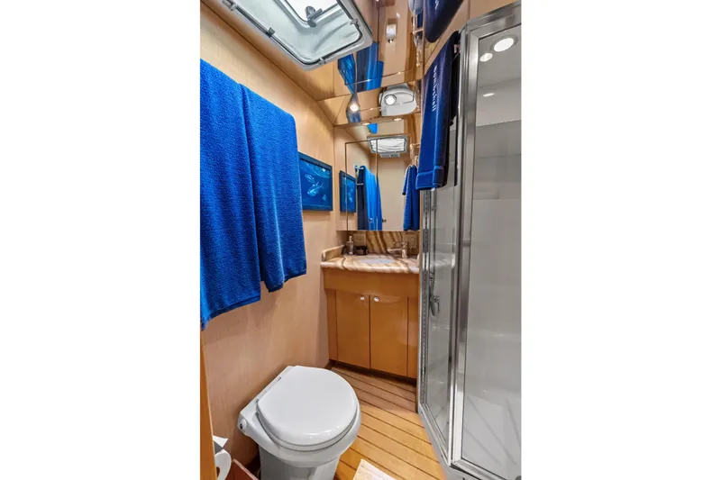 Slide: The Image of Luxurious bathroom in 2003 Hatteras 65 Convertible yacht with blue towels and modern fixtures. - 54