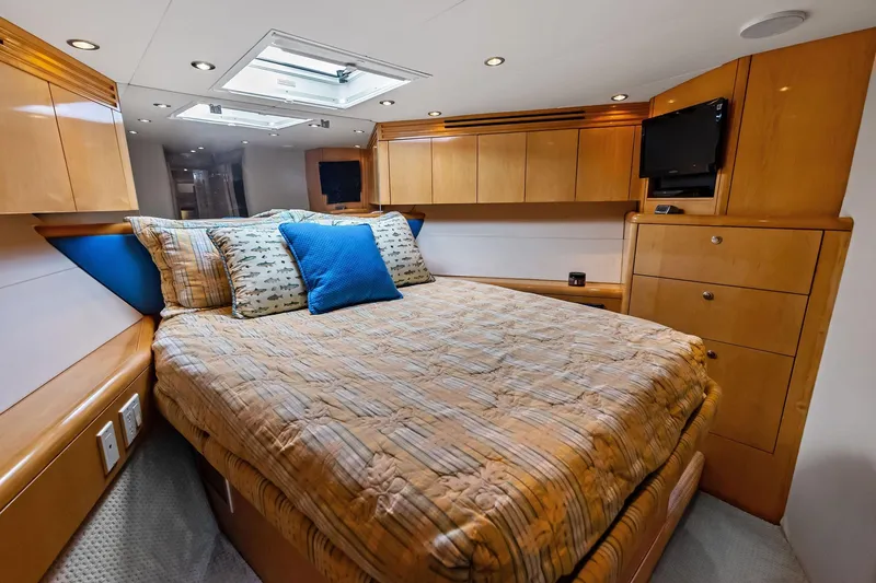 Slide: The Image of Luxurious cabin interior of 2003 Hatteras 65 Convertible yacht with cozy bed and wooden cabinetry. - 55