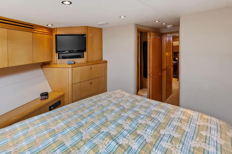 Slide: The Image of Luxurious cabin interior of 2003 Hatteras 65 Convertible yacht with TV and wood cabinetry. - 56
