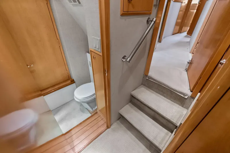 Slide: The Image of Interior of 2003 Hatteras 65 Convertible yacht, featuring stairs and a compact bathroom. - 57