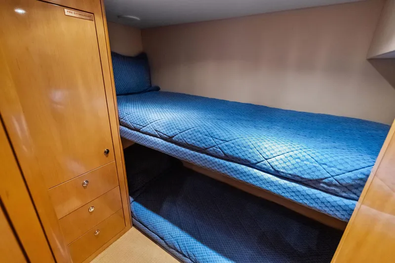 Slide: The Image of Bunk beds with blue bedding in 2003 Hatteras 65 Convertible yacht cabin. - 59