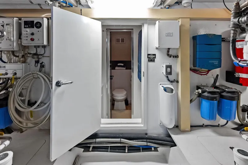 Slide: The Image of Engine room of 2003 Hatteras 65 Convertible yacht with visible equipment and open door. - 63