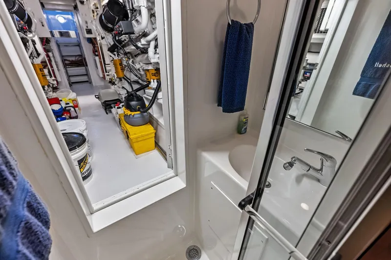 Slide: The Image of Engine room and bathroom of 2003 Hatteras 65 Convertible yacht, showcasing equipment and amenities. - 64