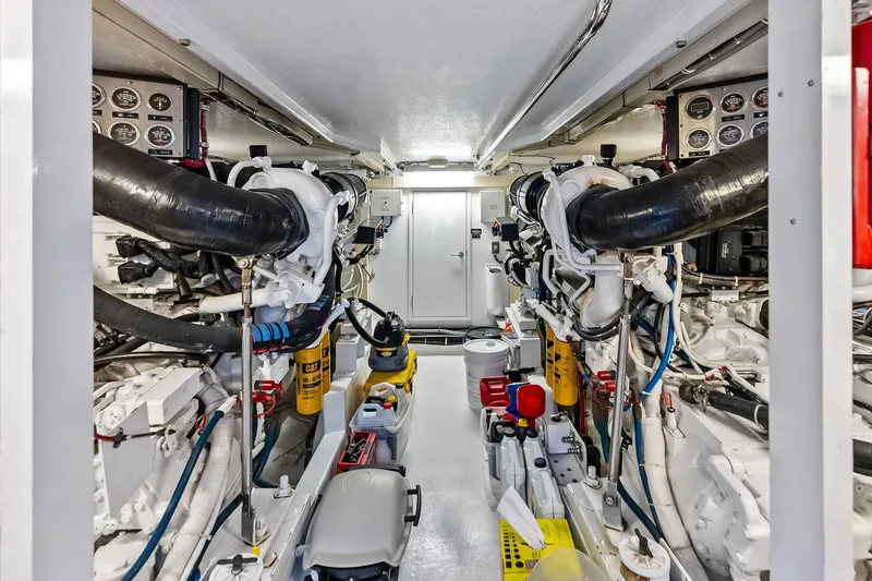 Slide: The Image of Engine room of 2003 Hatteras 65 Convertible yacht, featuring dual engines and control panels. - 66