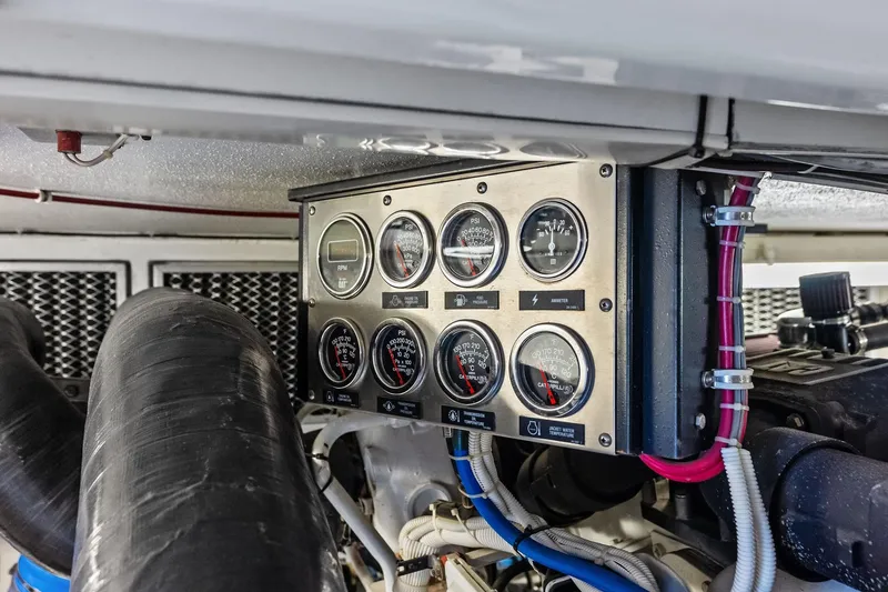 Slide: The Image of Engine control panel of a 2003 Hatteras 65 Convertible yacht, featuring gauges and wiring. - 68