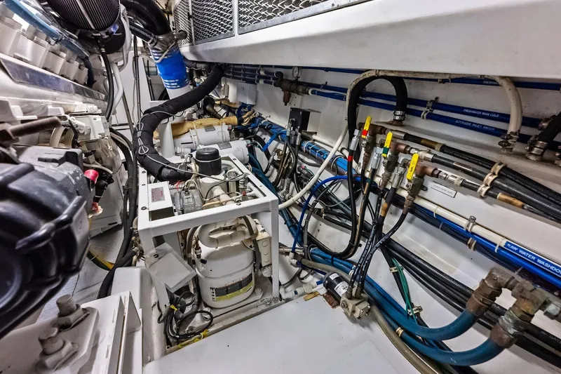 Slide: The Image of Engine room of 2003 Hatteras 65 Convertible yacht, showcasing complex machinery and piping. - 69