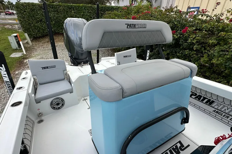 Slide: The Image of 2023 Pathfinder 2500 Hybrid boat interior with seating and console, surrounded by greenery. - 11