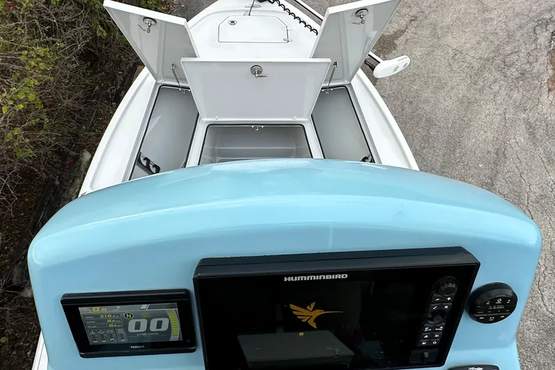 Slide: The Image of 2023 Pathfinder 2500 Hybrid boat dashboard with open storage compartments and navigation display. - 16