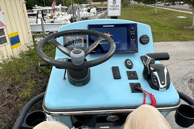 Slide: The Image of 2023 Pathfinder 2500 Hybrid boat dashboard with steering wheel and navigation system at Naples Marina. - 17