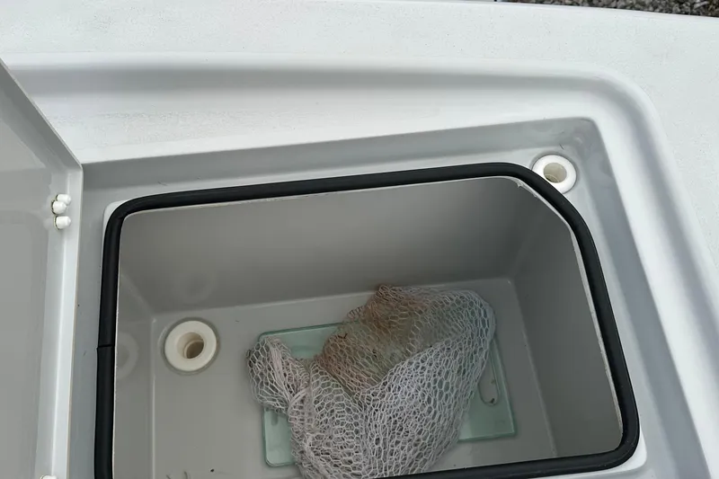 Slide: The Image of Open storage compartment in 2023 Pathfinder 2500 Hybrid boat with netting inside. - 8