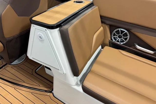 Slide: The Image of 2025 Yamaha Boats 252SE interior with tan seating, cup holder, and speaker detail. - 11