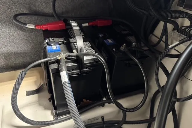 Slide: The Image of Battery compartment of 2025 Yamaha Boats 252SE with cables and connections. - 12