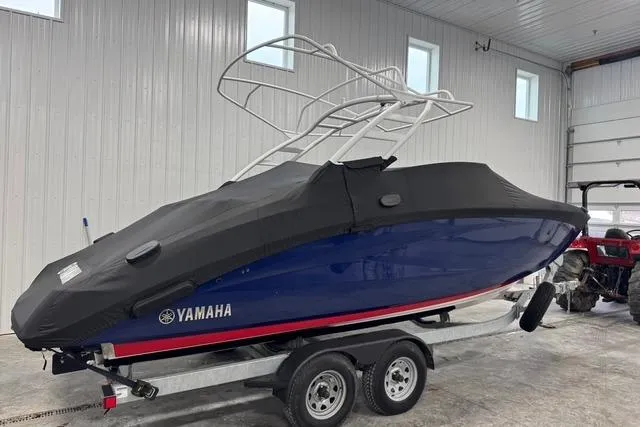 Slide: The Image of 2025 Yamaha Boats 252SE covered on trailer in indoor storage facility. - 2