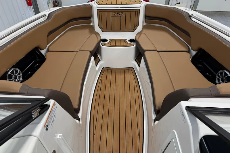 Slide: The Image of 2025 Yamaha Boats 252SE interior with tan seating and wood-style flooring. - 8