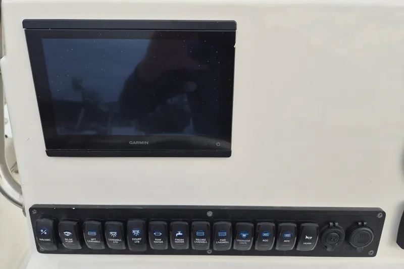 Slide: The Image of Control panel of 2026 Key West 210 Bay Reef boat with Garmin display and switches. - 14