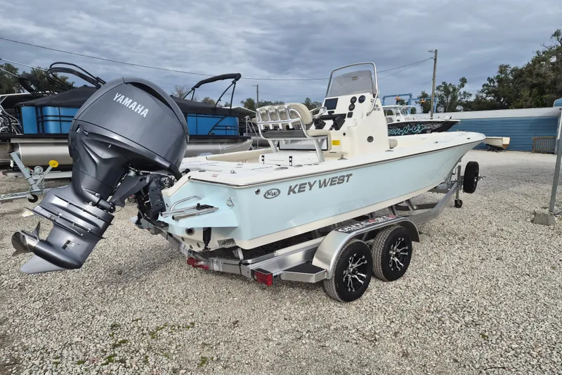 Slide: The Image of 2026 Key West 210 Bay Reef boat with Yamaha engine on trailer, parked outdoors. - 3