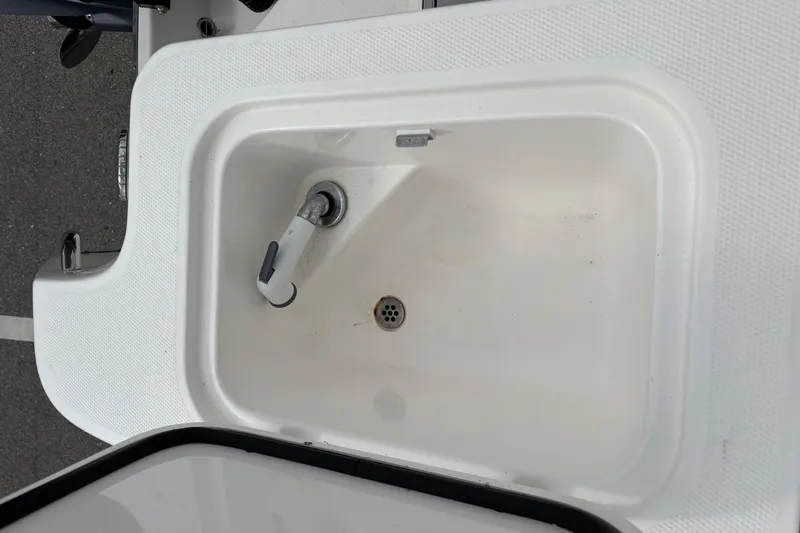 Slide: The Image of Edgewater 320CC 2015 boat sink with faucet, white basin, and drain. - 10