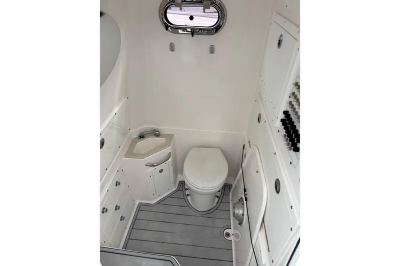 Slide: The Image of 2015 Edgewater 320CC boat interior bathroom with toilet and sink. - 12