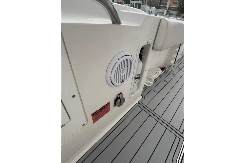 Slide: The Image of 2015 Edgewater 320CC boat interior with speaker, fire extinguisher, and coiled hose. - 13