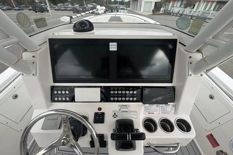 Slide: The Image of 2015 Edgewater 320CC boat dashboard with Garmin displays and steering wheel. - 19
