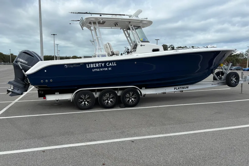 Slide: The Image of 2015 Edgewater 320CC boat on trailer in parking lot, side view. - 4
