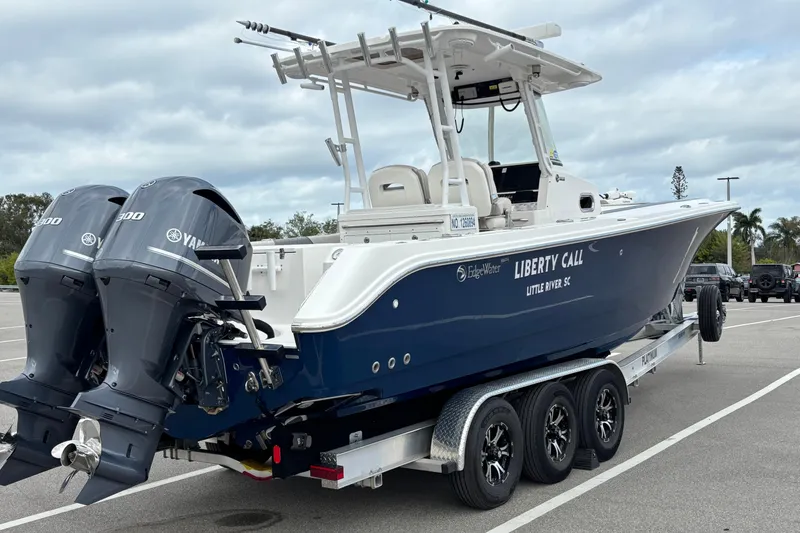 Slide: The Image of 2015 Edgewater 320CC boat on trailer with twin Yamaha engines, parked in a lot. - 5