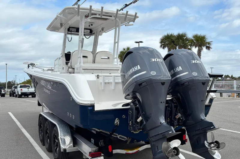 Slide: The Image of 2015 Edgewater 320CC boat with dual Yamaha 300 engines, parked on a trailer. - 6