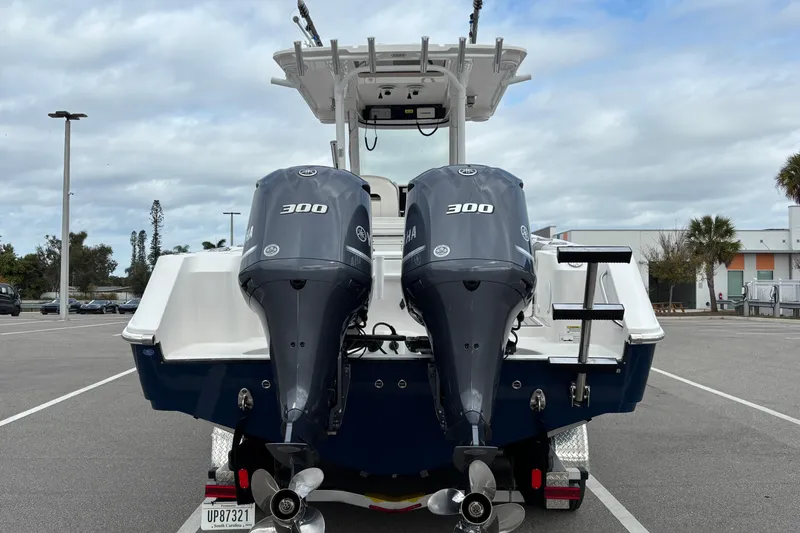 Slide: The Image of 2015 Edgewater 320CC boat with dual Yamaha 300 engines in a parking lot. - 9